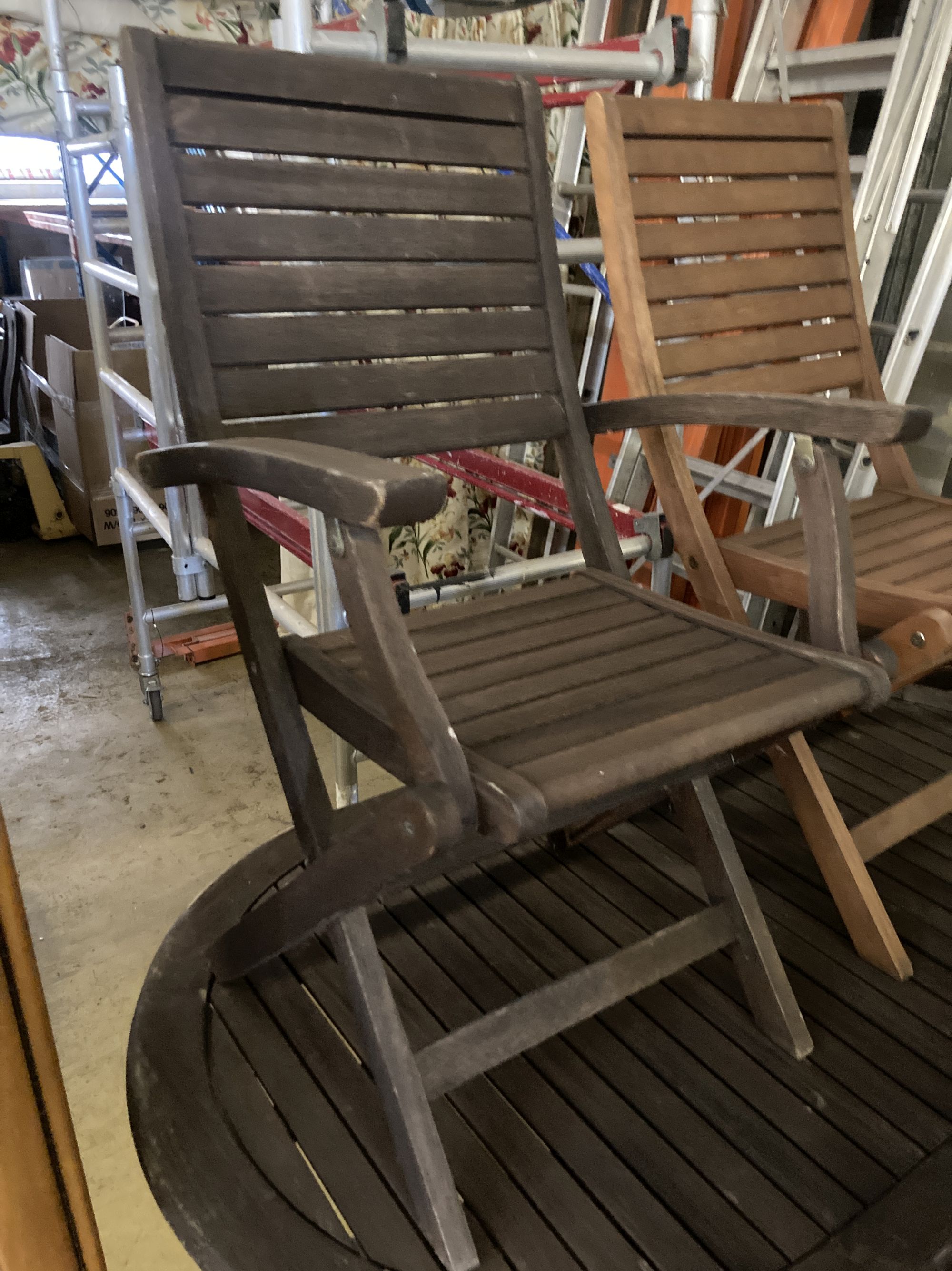 A weathered teak garden table and six teak folding chairs (two with arms)